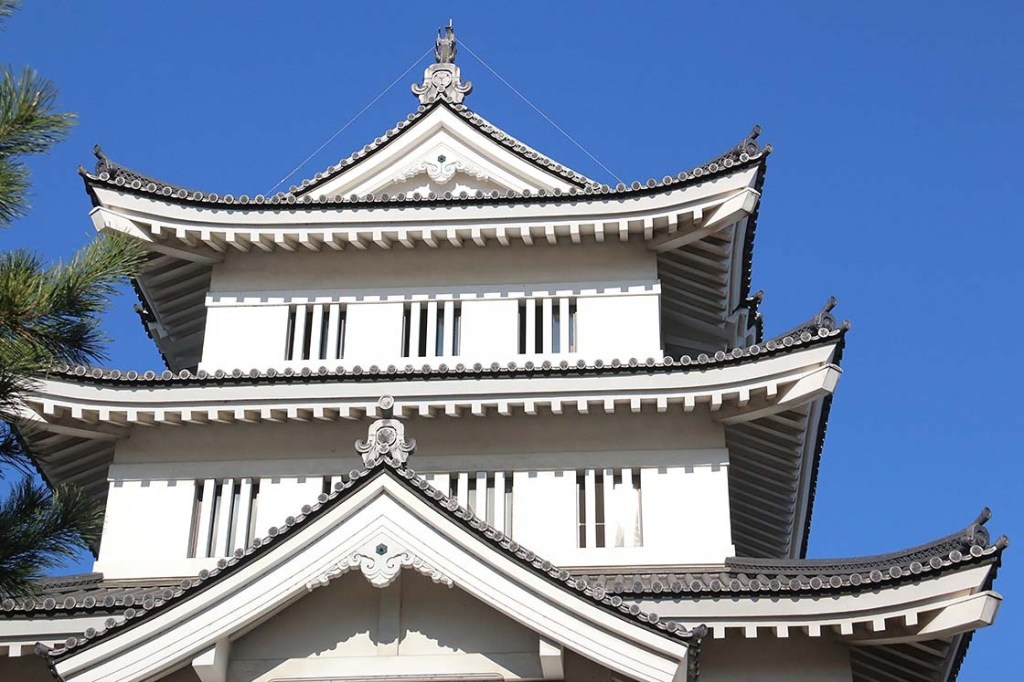 A white Japanese castle against a blue sky