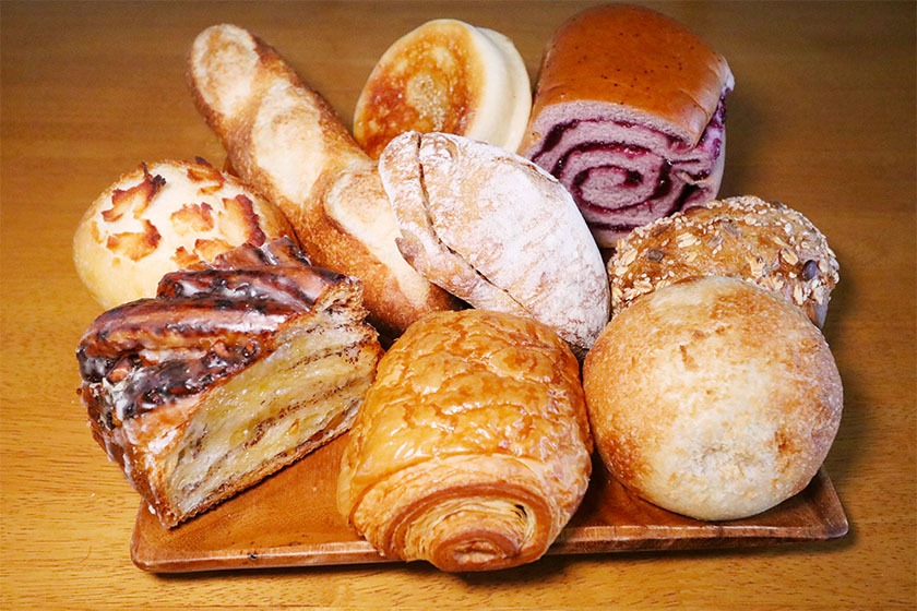 An array of different types of bread on a wooden background